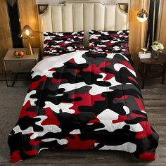 a bed with a red and black camouflage print comforter set on top of it