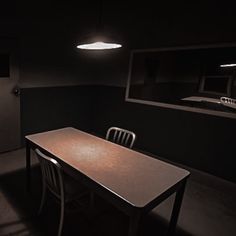 a dark room with a table and chairs