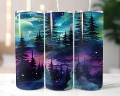 three tumbles painted with trees and the night sky in purple, blue, and green