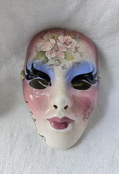 a white mask with flowers painted on it