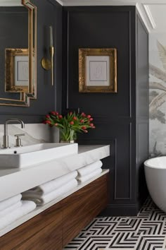 a bath room with a tub a sink and a painting on the wall next to it