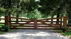 a wooden gate in the middle of a driveway