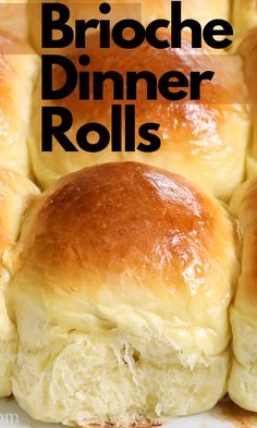 a close up of bread rolls on a plate with the words brioche dinner rolls