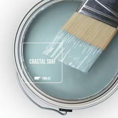 a paint can with a brush in it and the words coastal surf painted on it