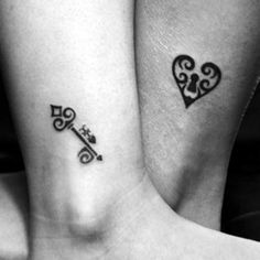 two people with matching tattoos on their legs, one has a key and the other has a heart