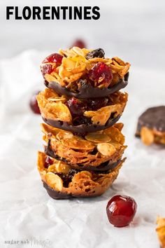 a stack of granola bites sitting on top of each other next to cherries