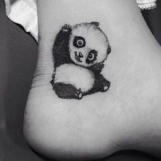 a small panda bear tattoo on the foot