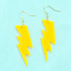 Bright yellow lightning bolt earrings, made of smooth, lightweight laser-cut acrylic, with gold tone hooks. 2.75 inches (7 cm) from hook to tip. Gold tone stainless steel hooks. Hypoallergenic and nickel free. Lightweight bright yellow acrylic. Lightning Clothes, Greek Party, Haunt Couture, Lightning Earrings, Yellow Lightning, Bolt Earrings, Homecoming Ideas, Yellow Accessories, Lightning Bolt Earrings