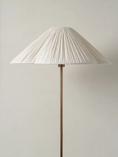 a lamp that is on top of a wooden table next to a white wall and floor