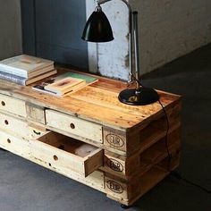 a wooden table with drawers and a lamp on top