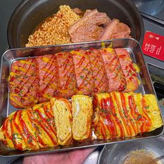 a person is holding up a tray with food in it and other dishes on the table