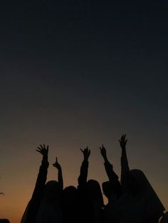 silhouettes of people reaching up into the sky