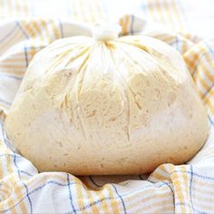 a bag of bread sitting on top of a blue and white checkered blanket