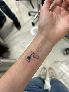 a person with a tattoo on their arm holding up a wine glass and corkscrew