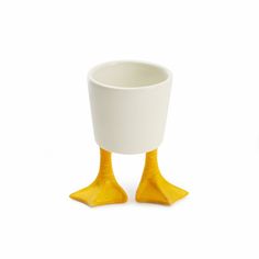 a white cup with yellow legs on a white background