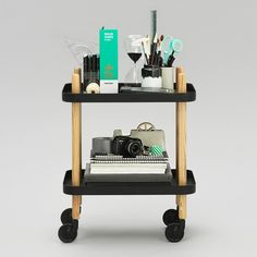 a black and wooden cart with various items on it's wheels, including a camera