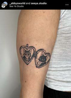 a woman's arm with two heart shaped tattoos on it, one has a cat and the other has a kitten