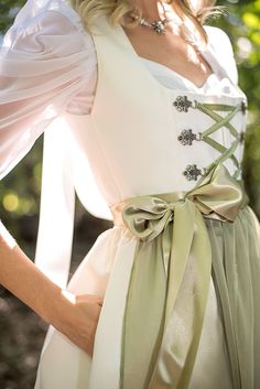 A bridal dirndl is a truly unique, elegant and fashionable way to celebrate your wedding day. Whether you are wearing it for your ceremony, reception or your rehearsal dinner, a made-to-order bridal dirndl is a perfect choice! Available in white or ivory, this bridal dirndl is sure to turn heads at your Oktoberfest-themed wedding Ivory or white satin bridal dirndl Pleated skirt length is 26" from the waist to the hemline 2 skirt pockets Classic square neckline with matching ivory piping Ribbon and chain lace-up bodice Elegant poly chiffon apron with wide ribbon apron ties Pictured with the Sweetheart Blouse with Draped Sleeves in white and Dirndl Petticoat - Last photo pictured with Tulle Top Skirt This dirndl made to order. Please allow 8-10 weeks for delivery Made with love in Chicago, I Oktoberfest Wedding, Bridal Dirndl, Wedding Dirndl, Square Necklines, Rehearsal Dinners, Square Neckline, White Wedding, Vogue, My Style