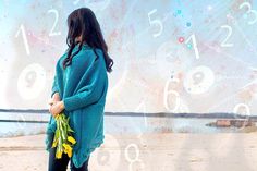 a woman standing in front of a wall with numbers on it and flowers in her hands