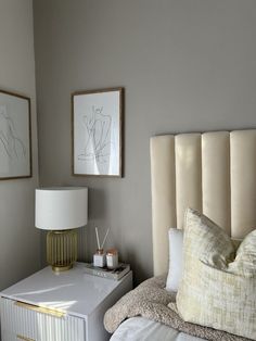 a bedroom with a bed, nightstand and pictures on the wall