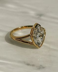 a gold ring with a pear shaped diamond