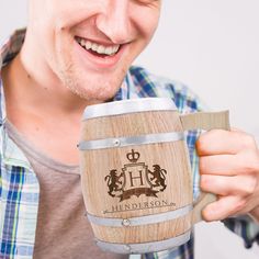 a man is holding a wooden barrel with the name hender son on it and smiling