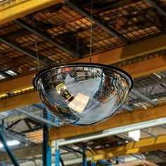 a large metal object suspended from the ceiling in a warehouse with other items on it