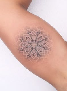 a woman's arm with a tattoo on it that has a flower design in the middle