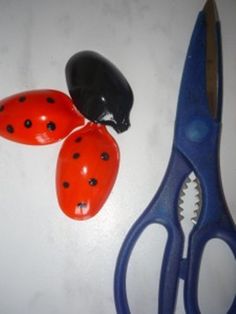 a pair of scissors with ladybugs on them sitting next to another pair of scissors