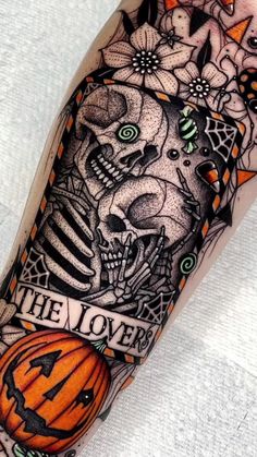 a black and white photo of a halloween themed tattoo on the arm, with an orange jack - o'- lantern