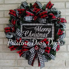 a christmas wreath hanging on the side of a brick wall with merry christmas written on it