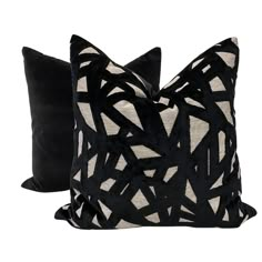 two black and white pillows sitting next to each other