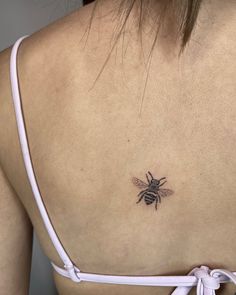 a woman with a bee tattoo on her back