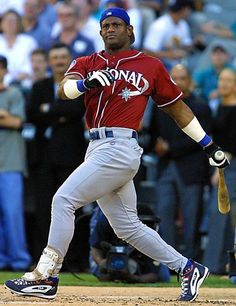 a baseball player swinging a bat on top of a field in front of a crowd