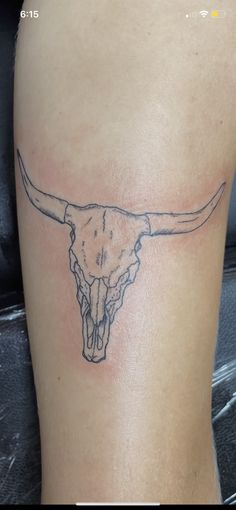 a bull skull tattoo on the back of a woman's thigh