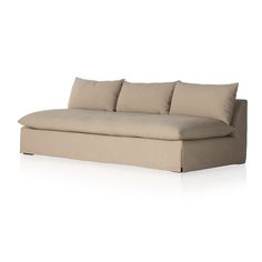 a beige couch with pillows on the top and bottom, sitting in front of a white background