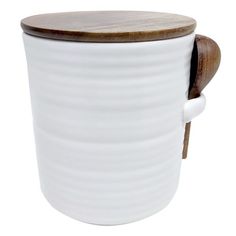 a white ceramic cup with a wooden lid