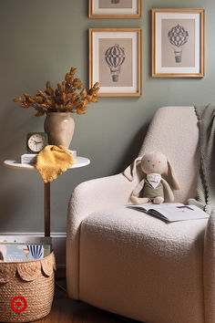 a chair with a stuffed animal sitting on top of it next to a vase filled with flowers