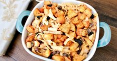 a casserole dish with apples and raisins in it on a wooden table