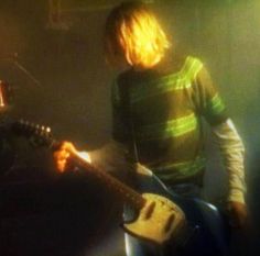 a young man playing an electric guitar on stage