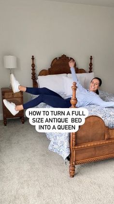 a woman laying on top of a bed next to a wooden headboard and foot board