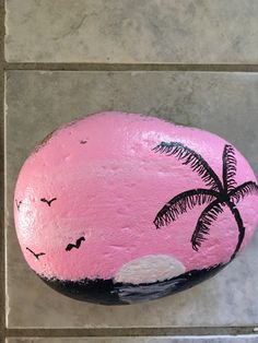 a painted rock with a palm tree on it