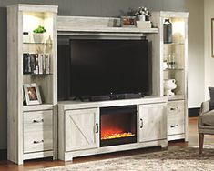 an entertainment center with a fireplace in the middle and shelves on either side, along with a chair