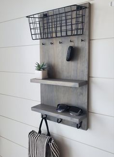 a wall mounted shelf with two baskets on it and a purse hanging from the bottom