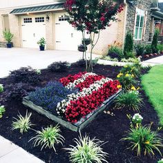 an american flag made out of flowers in front of a house with a driveway and garage