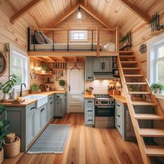 a kitchen with stairs leading up to the loft