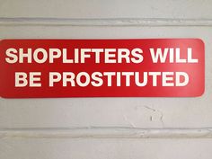 a red sign that says shoplifters will be prostitued on the wall