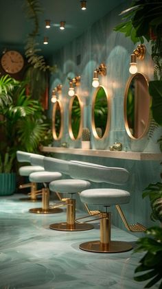 a row of white stools sitting in front of a wall with mirrors on it