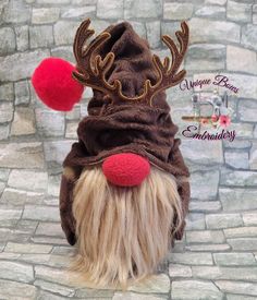 a dog wearing a reindeer hat with red pom poms on it's head