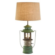 a green lamp with a brown shade on it and a white light in the middle